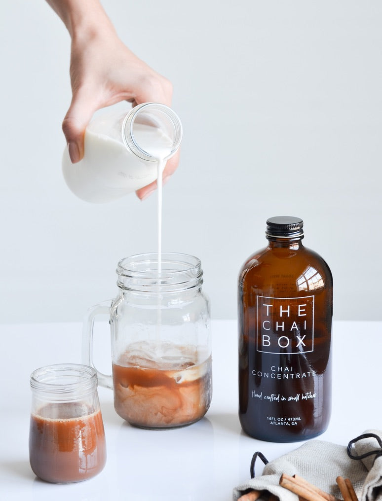 Milk being poured over chai concentrate cubes. The chai box concentrate is a convenient way to make iced chai. Ethical and Sustainable chai. 