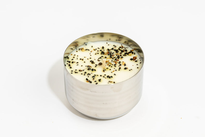 A white candle in a silver container
